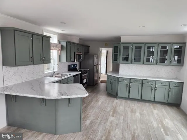 a kitchen with a sink cabinets and wooden floor