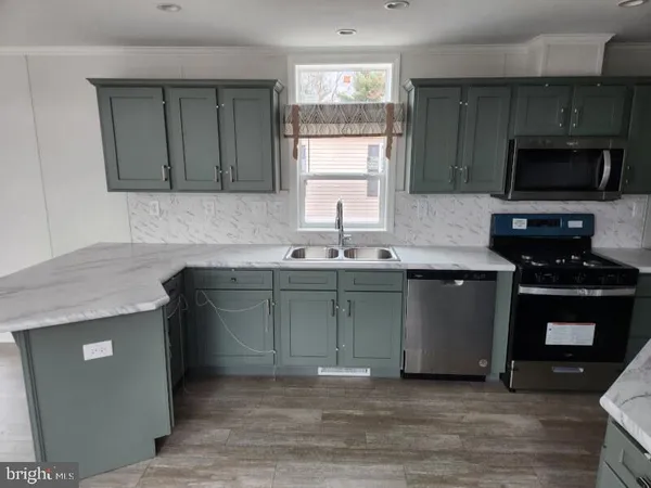 a kitchen with granite countertop a sink and a stove top oven