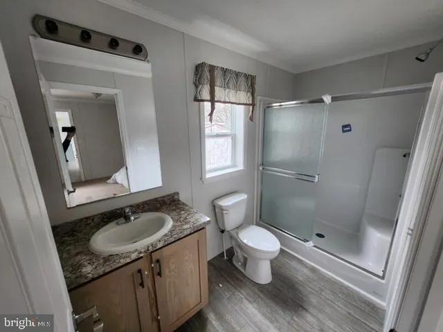 a bathroom with a granite countertop sink toilet a mirror and shower