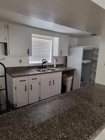 a kitchen with stainless steel appliances a sink a stove a refrigerator a counter top space and cabinets