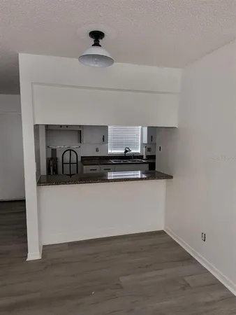 a kitchen with stainless steel appliances granite countertop a sink a stove and a wooden floors