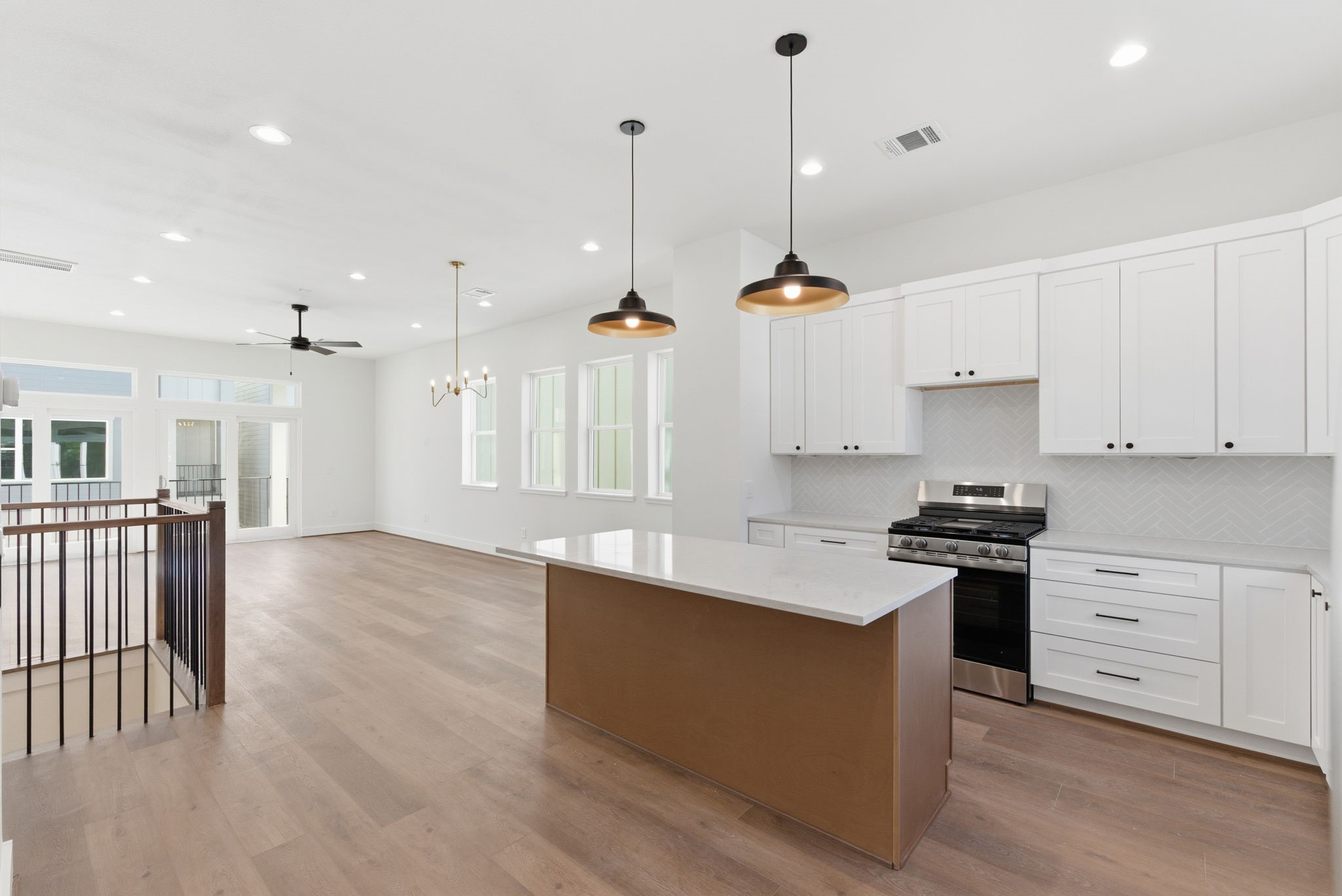 7706 Earl Rudder Way Houston, TX 77055 - Photo 21 of 46 a kitchen with stainless steel appliances granite countertop a sink a stove a refrigerator and white cabinets with wooden floor