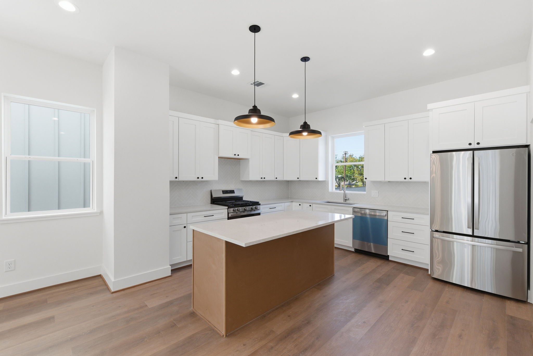 7706 Earl Rudder Way Houston, TX 77055 - Photo 24 of 46 a kitchen with a sink a refrigerator and wooden floor