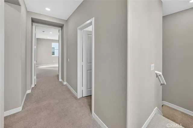 a view of a hallway with closet and bathroom