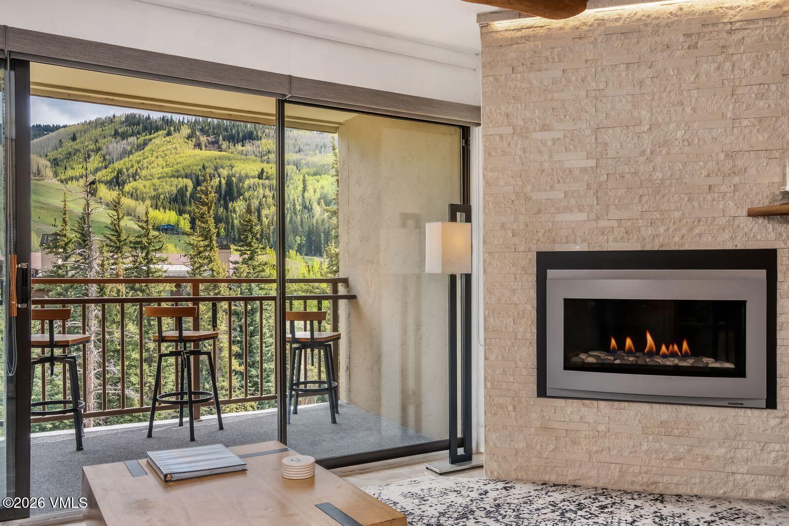 500 South Frontage Road East, Unit 308 Vail, CO 81657 - Photo 3 of 25 a living room with a fireplace and a floor to ceiling window