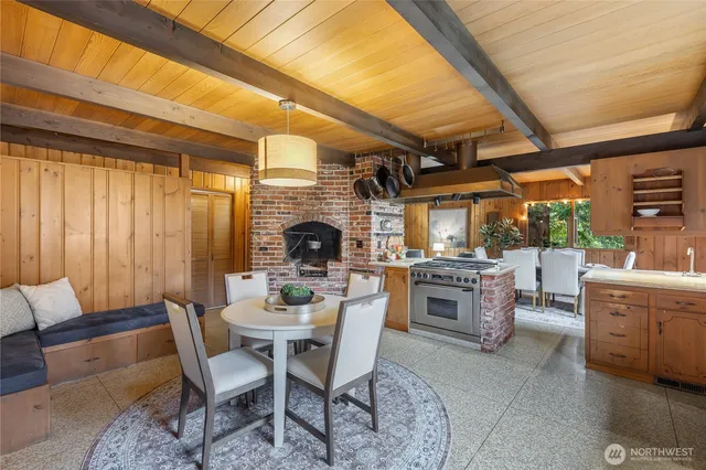 a dining room with furniture a fireplace and wooden floor
