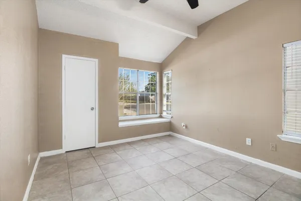 an empty room with fan and entrance