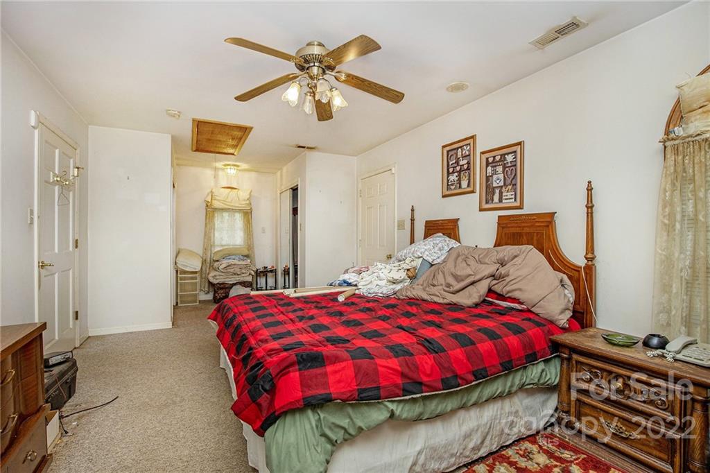 340 Sally Blackwell Road Pageland, SC 29728 - Photo 18 of 30 a bedroom with a bed and a chandelier