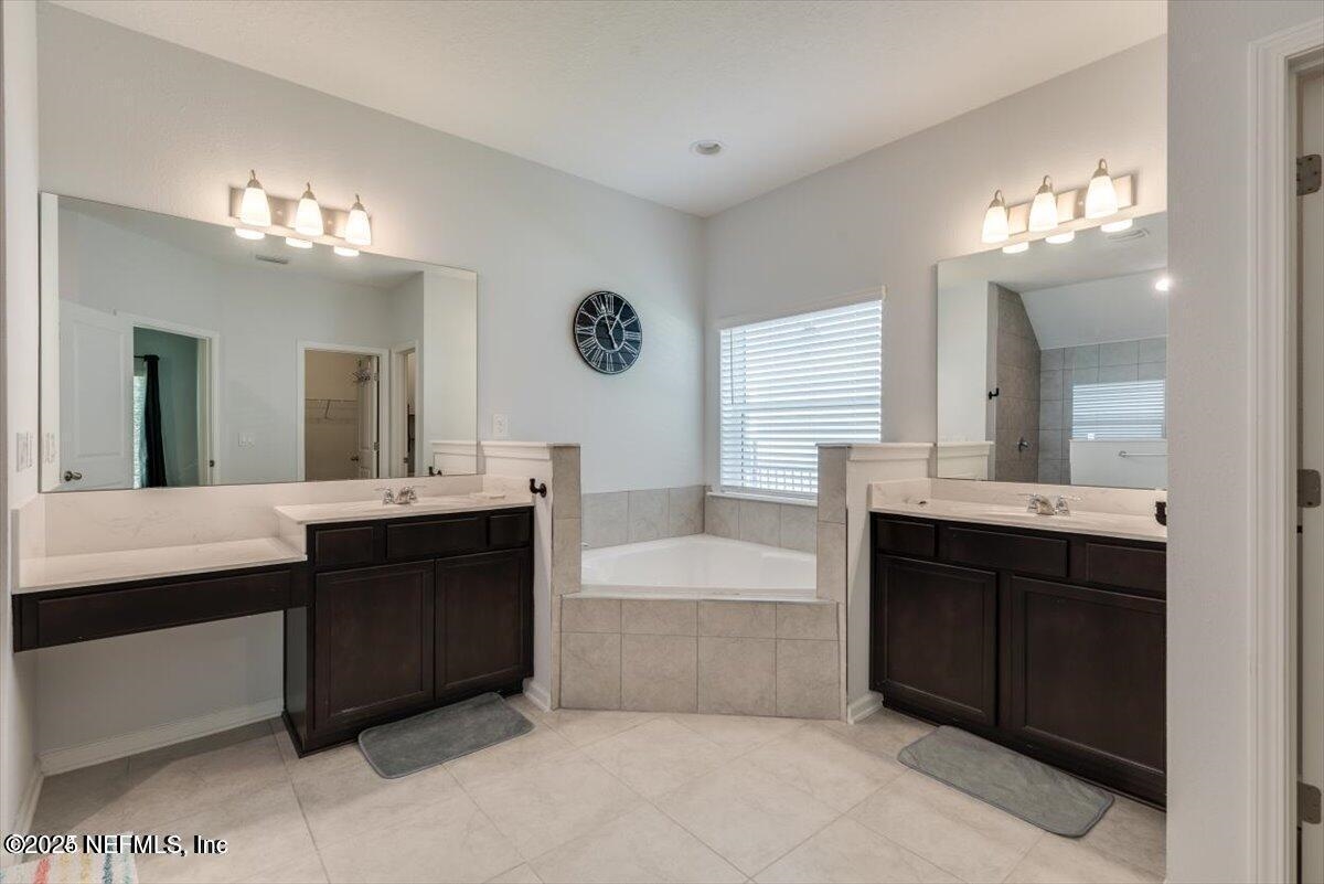 668 Watervale Drive St. Augustine, FL 32092 - Photo 8 of 17 a bathroom with a tub double vanity sink and a mirror