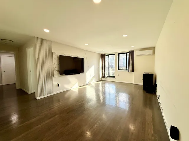 a view of a livingroom with wooden floor and flat screen tv