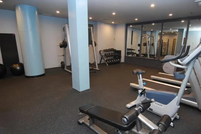a room with gym equipment and large mirror