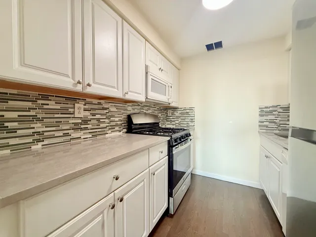 a kitchen with stainless steel appliances granite countertop a sink and a stove