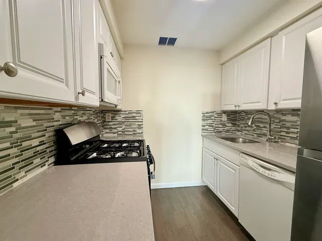 a kitchen with wooden cabinets and a stove top oven