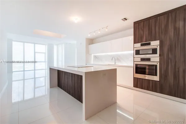 a kitchen with kitchen island cabinets and oven