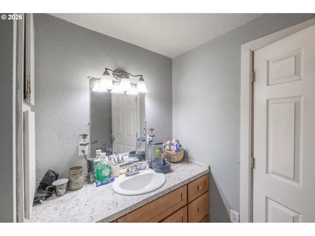a bathroom with a granite countertop sink and a mirror