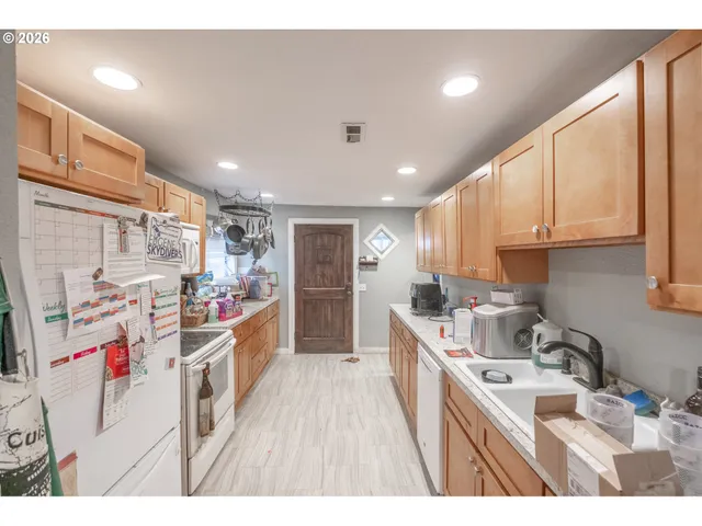 a kitchen that has a lot of cabinets a sink and wooden floor