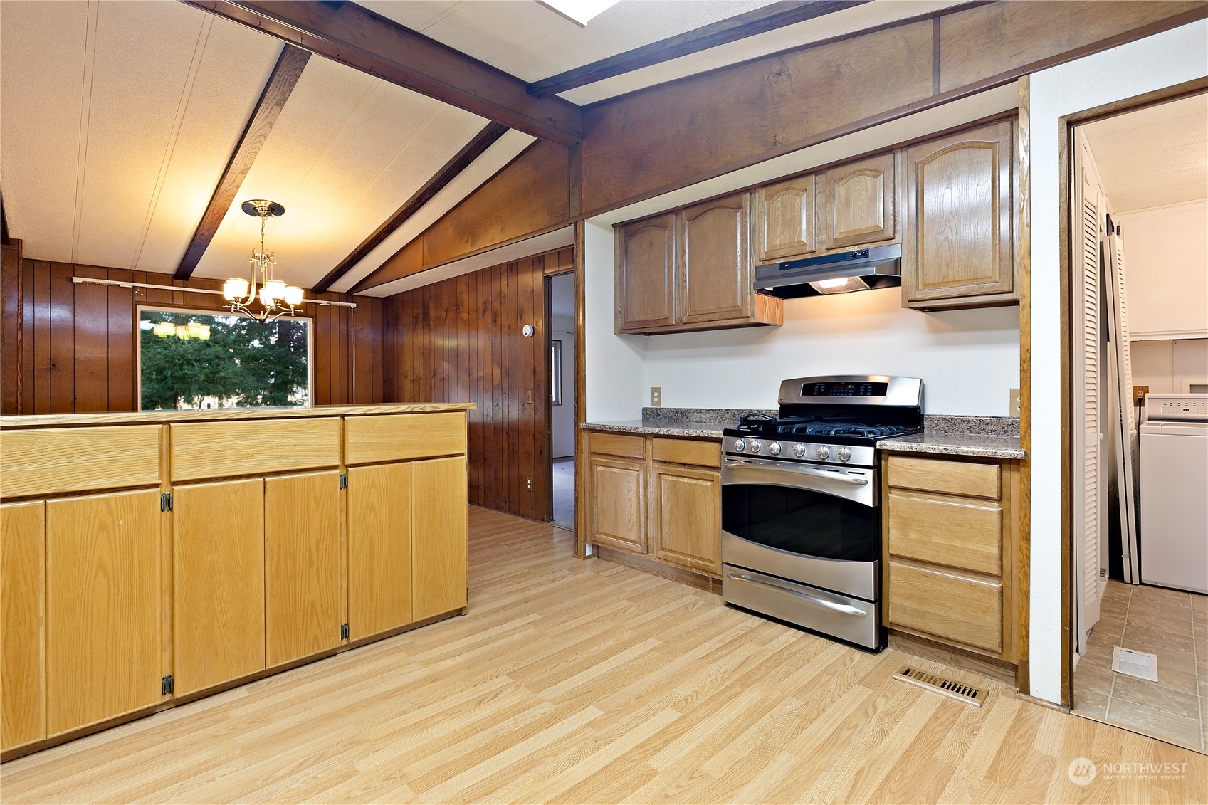 18124 Wakly Lane Southwest Rochester, WA 98579 - Photo 8 of 30 a kitchen with stainless steel appliances kitchen island granite countertop a stove a refrigerator and cabinets with wooden floor