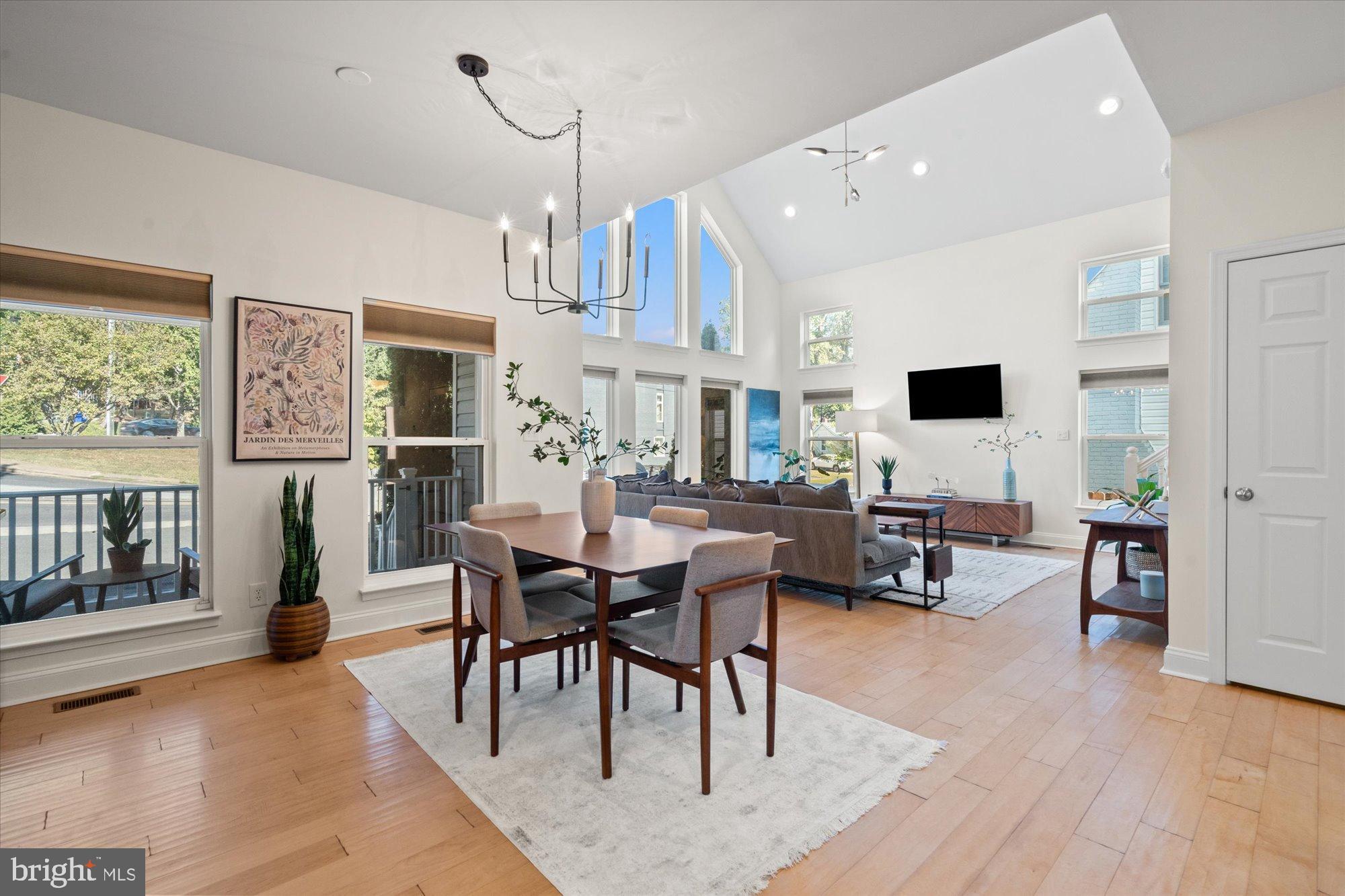 a living room with furniture a dining table and a floor to ceiling window