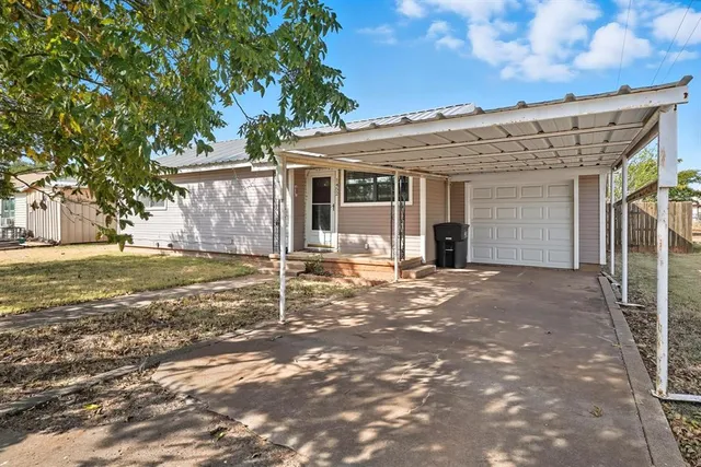 a view of a house with backyard and a tree