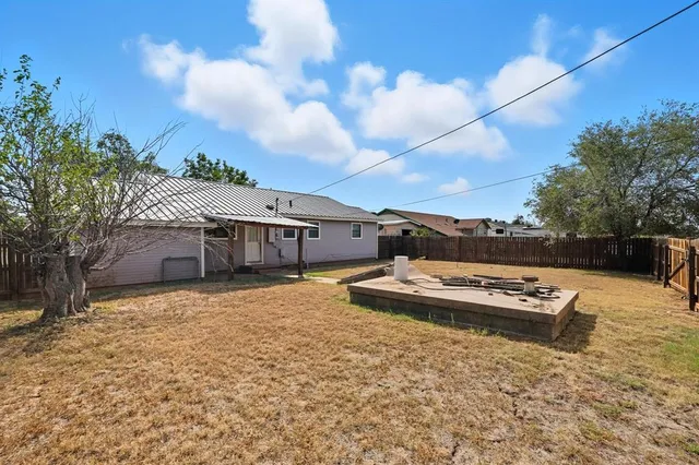 a view of a house with backyard and trees