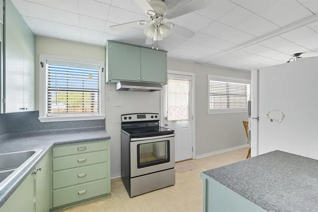 a kitchen with cabinets stainless steel appliances and window