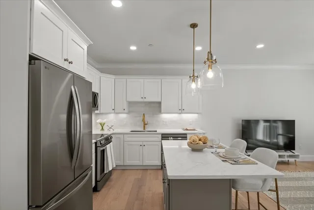 a kitchen with stainless steel appliances a refrigerator sink and wooden floor