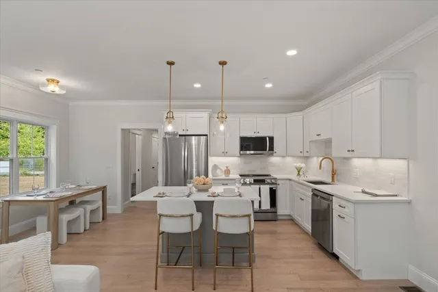a kitchen with a sink white cabinets and stainless steel appliances