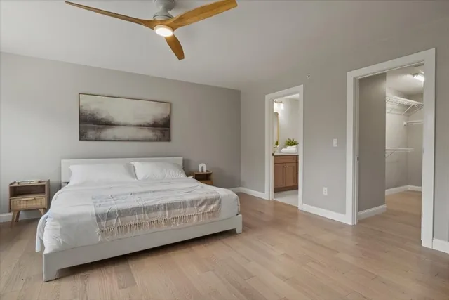 a bedroom with a bed and painting on the wall