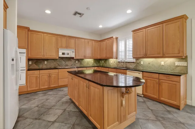 a kitchen with granite countertop a sink stove and cabinets