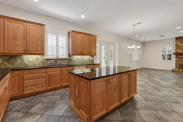 a kitchen with granite countertop a sink and cabinets