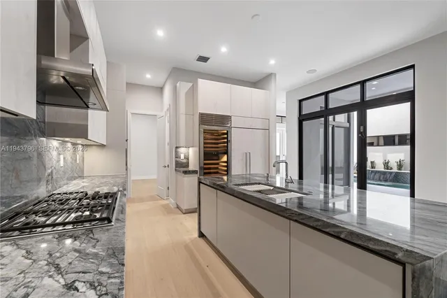 a kitchen with stainless steel appliances a sink stove and cabinets