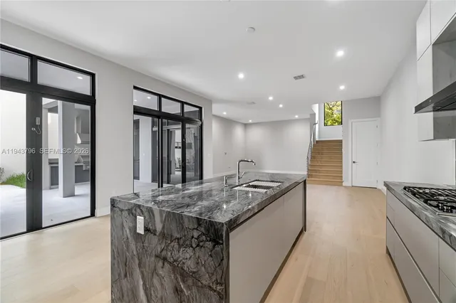 a kitchen with stainless steel appliances granite countertop a stove a sink and a refrigerator