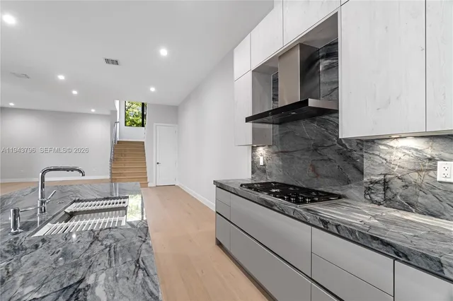 a kitchen with granite countertop a stove and a sink