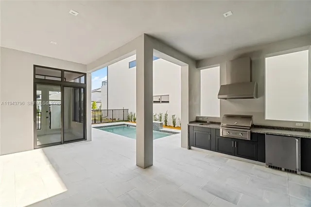 a open kitchen with granite countertop a refrigerator and a stove top oven