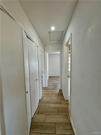 a view of a hallway with wooden floor and closet area