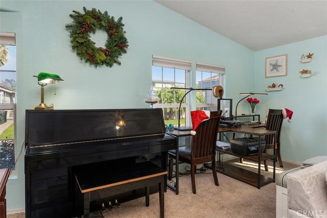 a living room with furniture a piano and a lamp