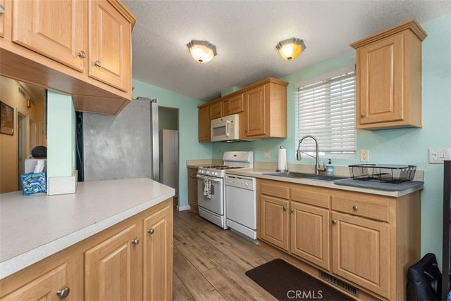 a kitchen with granite countertop a sink stove and cabinets