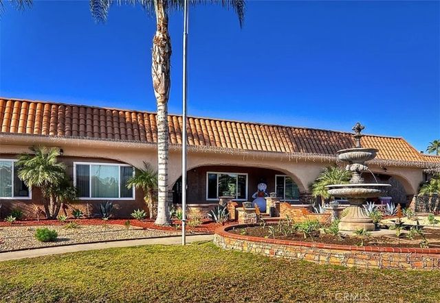 a view of a house with swimming pool patio and wooden fence