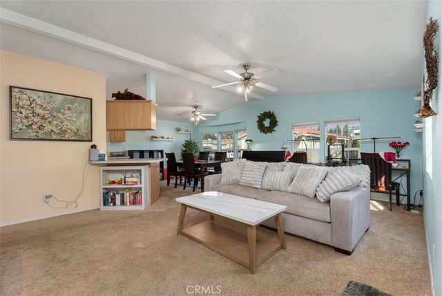 a living room with furniture kitchen view and a window