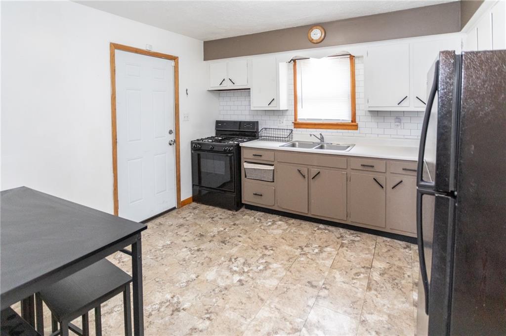 105 Jones Street Everson, PA 15631 - Photo 12 of 17 a kitchen with granite countertop a refrigerator stove top oven and sink