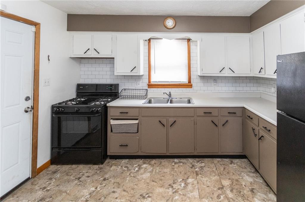 105 Jones Street Everson, PA 15631 - Photo 13 of 17 a kitchen with a stove sink and cabinets