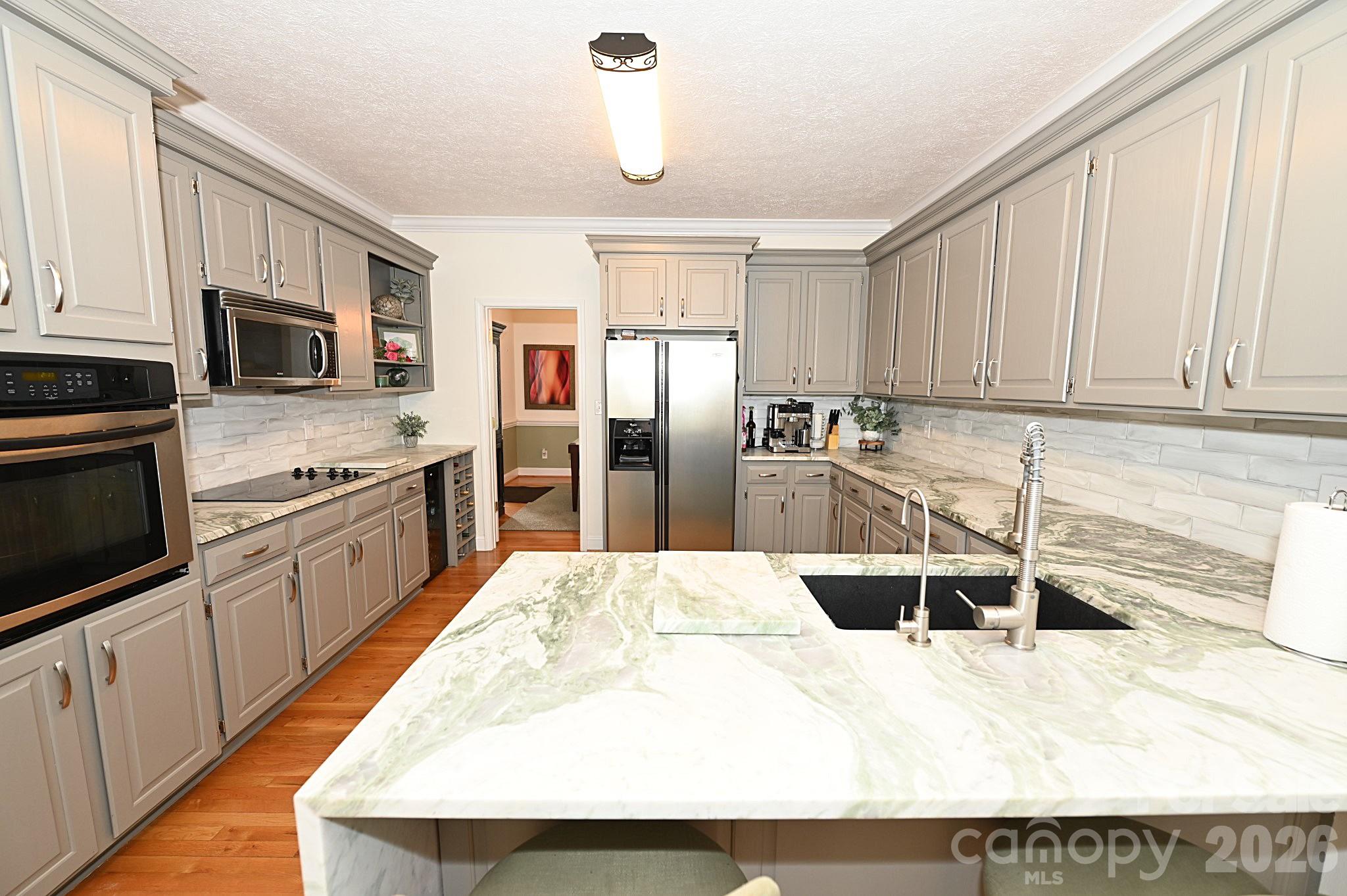 406 5th Avenue Northeast Conover, NC 28613 - Photo 17 of 46 a kitchen with stainless steel appliances kitchen island granite countertop a refrigerator oven a stove with white cabinets