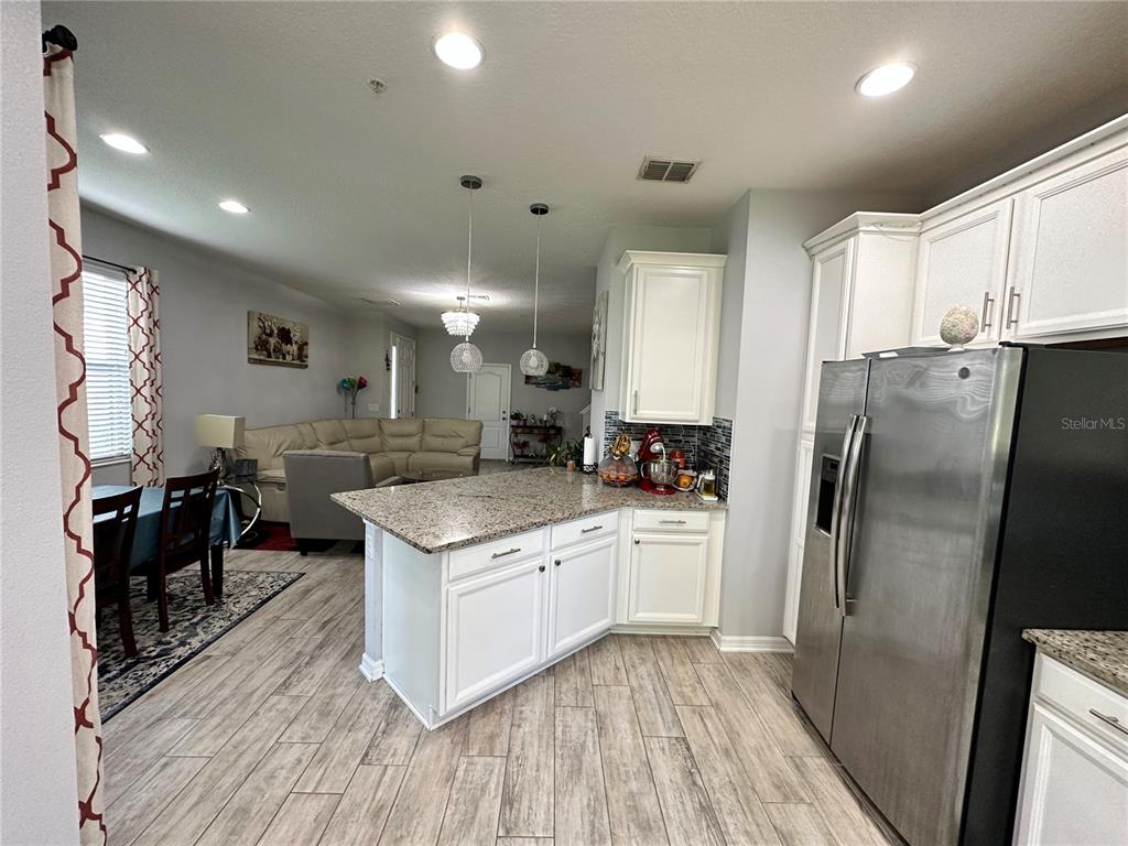 250 Rustic Loop Sanford, FL 32771 - Photo 6 of 33 a kitchen with stainless steel appliances granite countertop a refrigerator a stove and a wooden floors