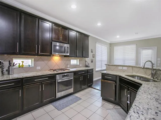 a kitchen with stainless steel appliances granite countertop wooden cabinets a sink and dishwasher