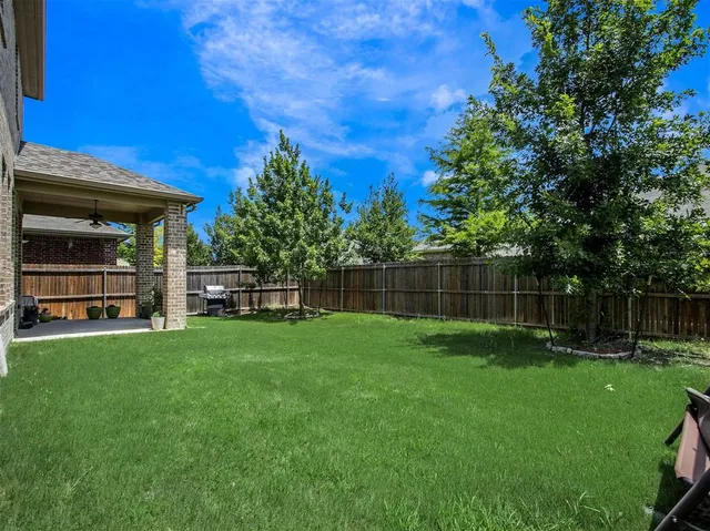 a view of a backyard with table and chairs and wooden fence