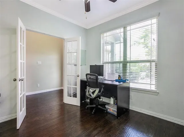 a view of a workspace with wooden floor and a window