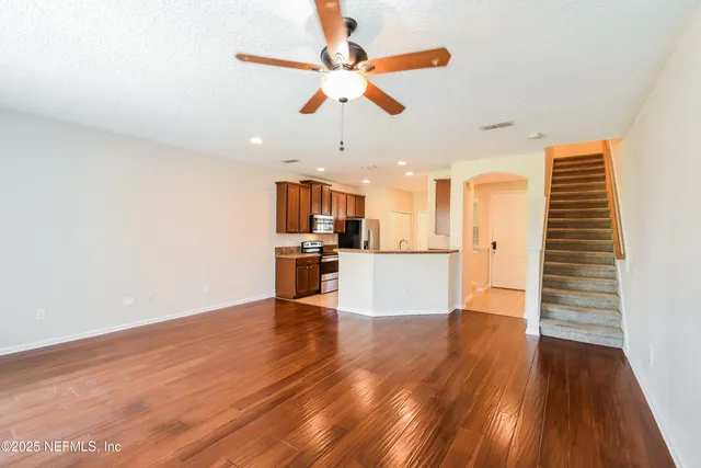 a view of a kitchen with wooden floor and a ceiling fan