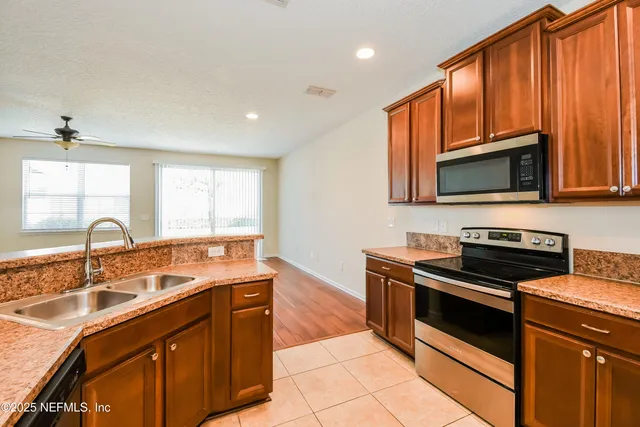 a kitchen with stainless steel appliances granite countertop a sink stove and microwave