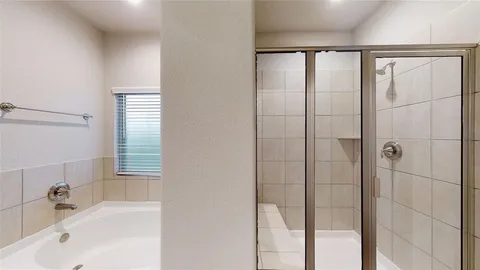 a bathroom with a bathtub and a shower