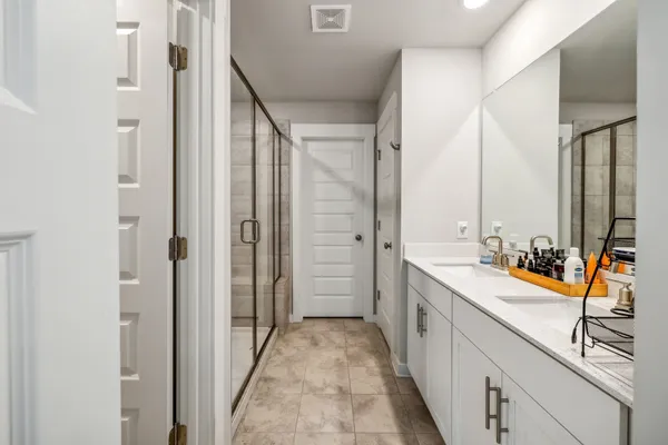 a bathroom with a double vanity sink a mirror and a bathtub
